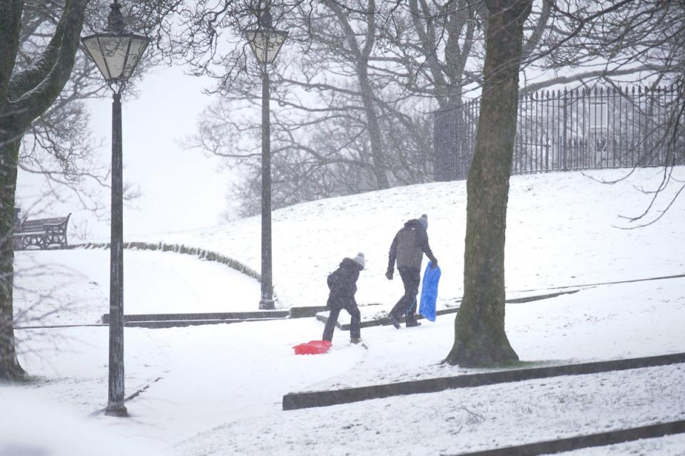 Children sledding in the snow on Thursday morning (PA)