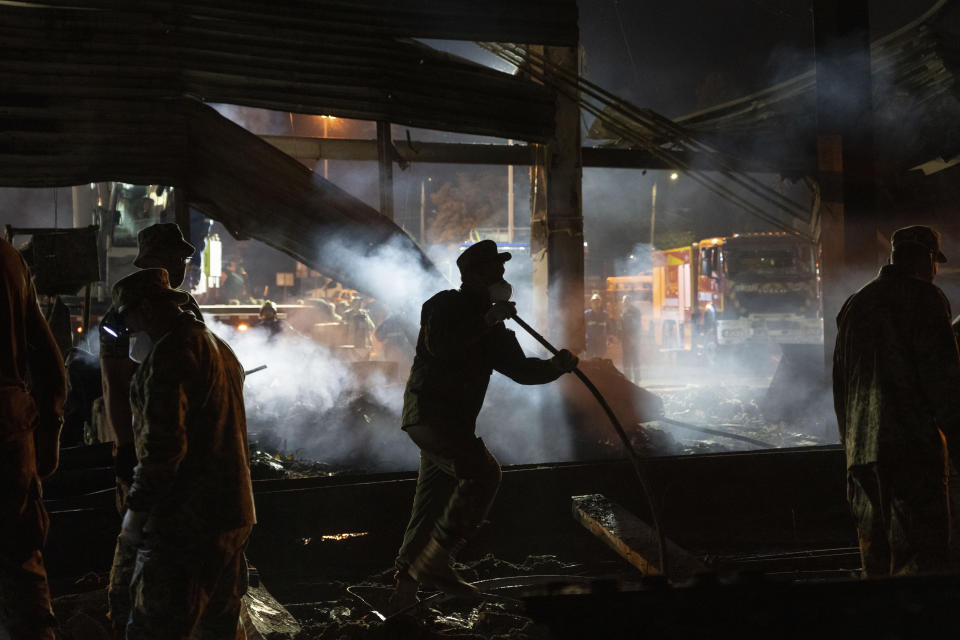 Volunteers and State Emergency Service firefighters work to extinguish a fire at a shopping center burned after a rocket attack in Kremenchuk, Ukraine, early Tuesday, June 28, 2022. (AP Photo/Efrem Lukatsky)