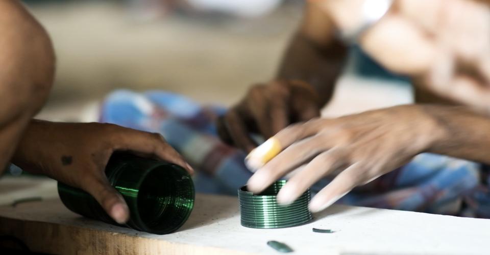 workers handle formed bangles with their bare hands