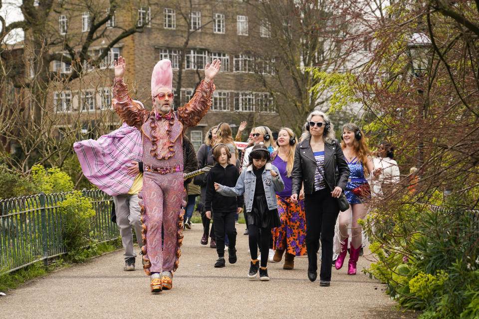 People dressed in costumes take part in a silent disco event outside the Brighton Dome, in Brighton, England, Saturday, April 6, 2024. Fans are celebrating 50 years since ABBA won its first big battle with “Waterloo.” A half century ago on Saturday, April 6, the Swedish quartet triumphed at the 1974 Eurovision Song Contest with the peppy love song. (AP Photo/Alberto Pezzali)