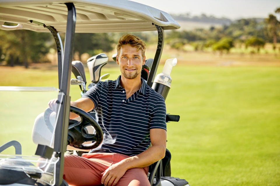 A person driving a golf cart around the course