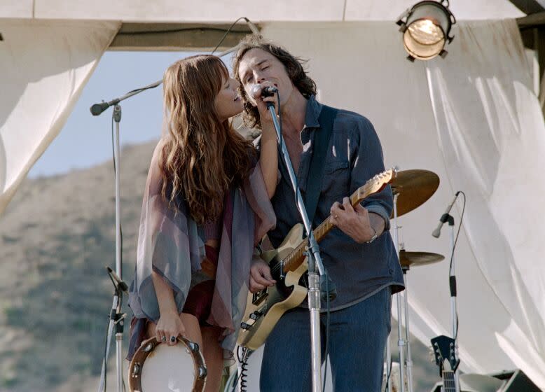 This image released by Amazon shows Sam Claflin, right, and Riley Keough in a scene from "Daisy Jones & The Six." (Lacey Terrell/Amazon via AP)