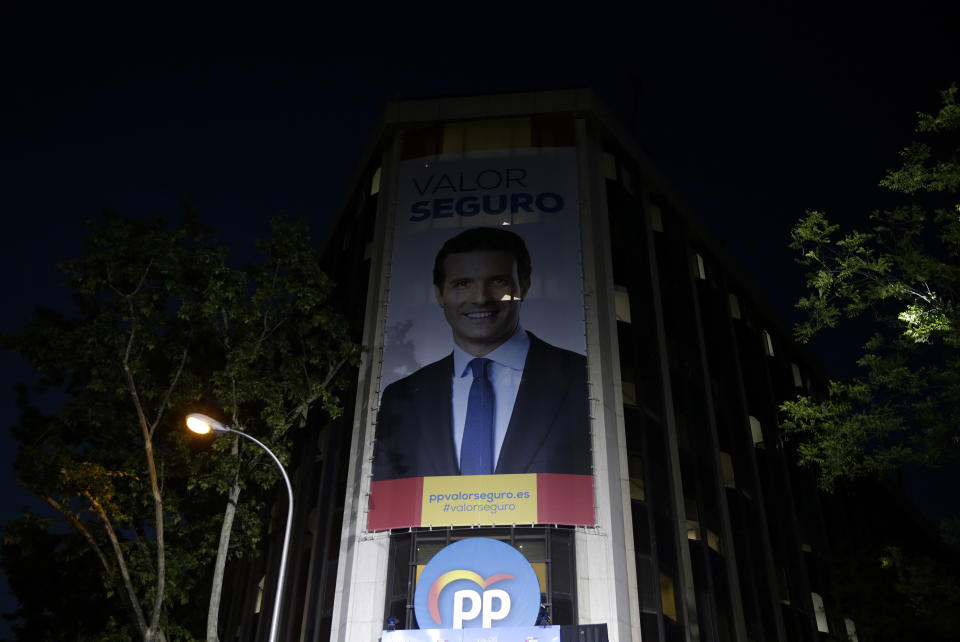 An poster featuring Popular Party leader Pablo Casado looks down from a building on election day in Madrid, Sunday, April 28, 2019. A divided Spain voted Sunday in its third general election in four years, with all eyes on whether a far-right party will enter Parliament for the first time in decades and potentially help unseat the Socialist government. (AP Photo/Andrea Comas)