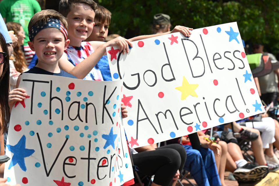 Declan LeBaron and his brother Caden LeBaron show their self-made signs to service members during the Doylestown Memorial Day Parade.