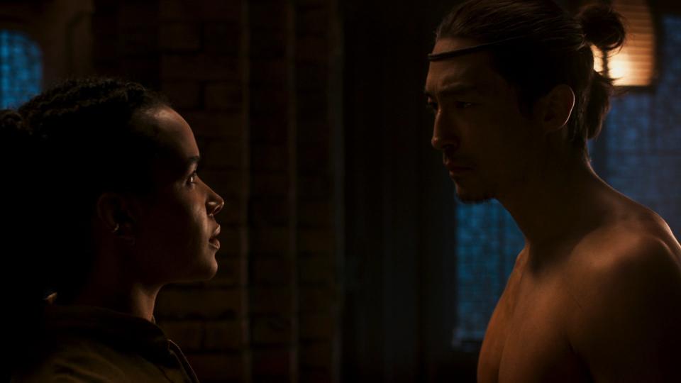 A close-up shot of Nynaeve and a shirtless Lan looking at each other