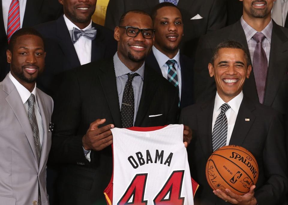 U.S. President Barack Obama (R) stands with Miami Heat players, including Dwyane Wade (L), LeBron James (2nd-L), Mario Chalmers (2R) during an event to honor the NBA champion Miami Heat in the East Room at the White House on January 28, 2013 in Washington, DC. President Barack Obama congratulated the 2012 NBA champions for claiming their third NBA Championship by beating the Boston Celtics. (Photo by Mark Wilson/Getty Images)