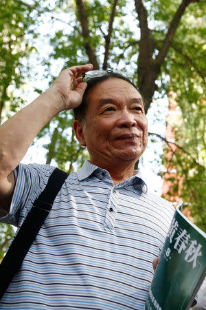 Wang Yanjun, former vice editor-in-chief of the liberal magazine Yanhuang Chunqiu, also known as China Through the Ages, holds an issue of the magazine as he speaks to the media outside the Chaoyang District Court in Beijing, China, August 16, 2016. REUTERS/Thomas Peter