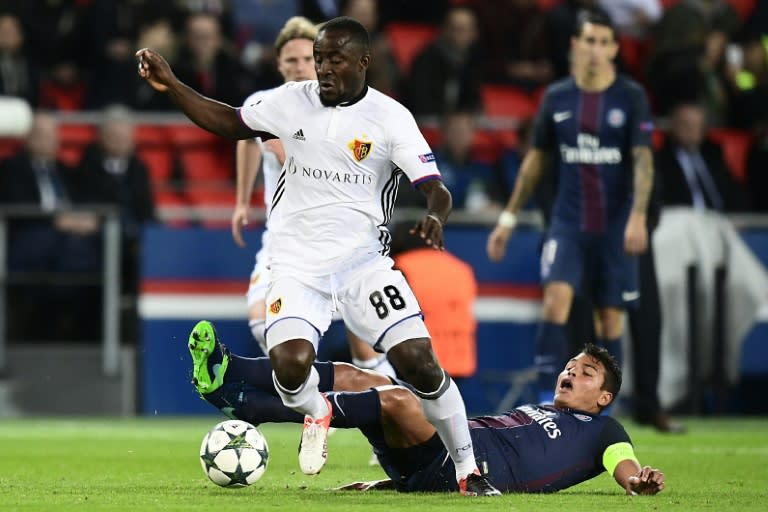 Basel's Seydou Doumbia fights for the ball with Paris Saint-Germain's Thiago Silva (R) during their UEFA Champions League Group A match, at the Parc des Princes stadium in Paris, on October 19, 2016