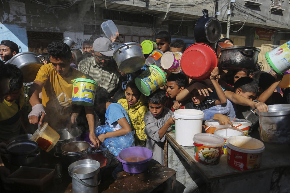 Palestinians crowd together as they wait for food distribution in Rafah, southern Gaza Strip, Wednesday, Nov. 8, 2023. (AP Photo/Hatem Ali)