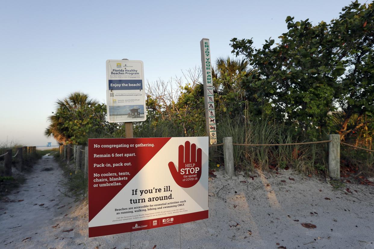 A sign leading to the beach outlines the rules for using Siesta beach on Monday, April 27, 2020, in Siesta Key, Fla. Sarasota county officials reopened the beach early this morning to essential activities, such as exercising.