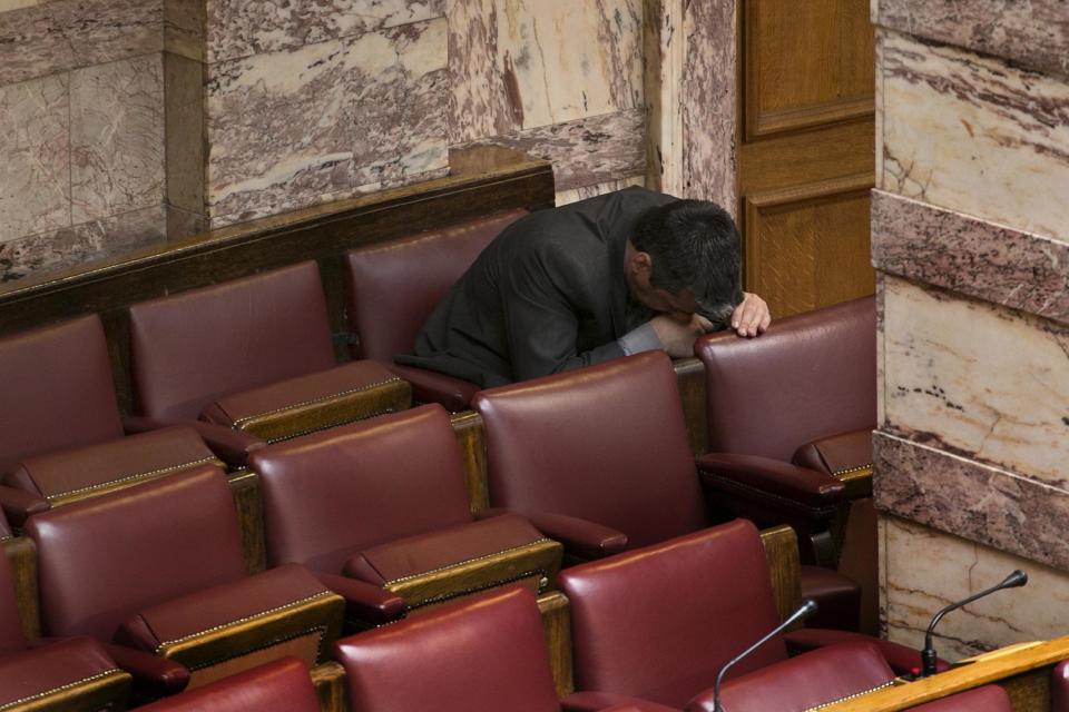 Greek lawmaker Efstathios Boukouras, whom the Golden Dawn party expelled this year, and who is one of five party lawmakers jailed pending trial for allegedly running a criminal organization, looks down before his speech during a parliamentary session in Athens, on Wednesday, May 7, 2014. Two jailed Greek lawmakers granted special prison leave have appeared in Parliament to defend themselves against charges linked with a judicial crackdown on the Nazi-inspired Golden Dawn party. (AP Photo/Petros Giannakouris)