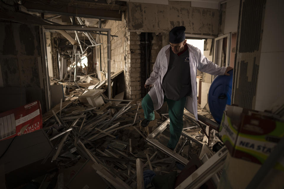 Ukrainian doctor Yurii Kuznetsov walks through the destroyed surgery section of the hospital in Izium, Ukraine, Sunday, Feb. 18, 2023. Russian attacks have devastated Ukraine's health care system, raining down explosions upon hospitals and ambulances at a rate of nearly two a day for the past year, according to a study that attempted to document each strike.(AP Photo/Vadim Ghirda)