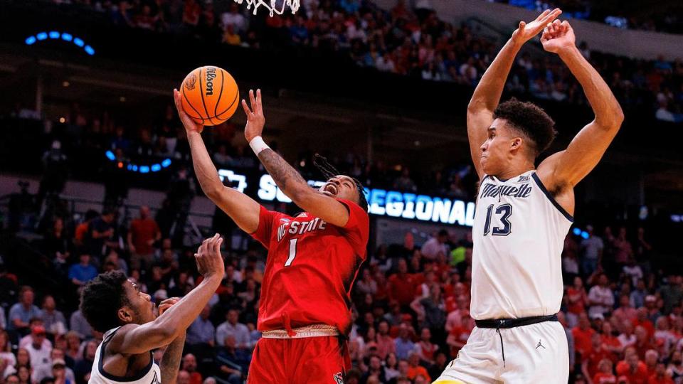 N.C. State’s Jayden Taylor drives to the basket between Marquette’s Kam Jones and Oso Ighodaro during the first half of the Wolfpack’s NCAA Tournament Sweet 16 matchup on Friday, March 29, 2024, at American Airlines Center in Dallas, Texas.