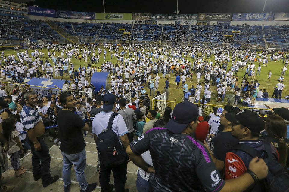 Fans take to the field of Cuscatlan stadium in San Salvador, El Salvador, Saturday, May 20, 2023. At least nine people were killed and dozens more injured when stampeding fans pushed through one of the access gates at a quarterfinal Salvadoran league soccer match between Alianza and FAS. (AP Photo/Milton Flores)