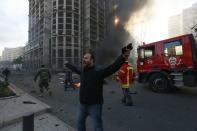 A security personnel shouts as smoke rises from the site of an explosion in Beirut's downtown area December 27, 2013. Former Lebanese minister Mohamad Chatah, who opposed Syrian President Bashar al-Assad, was killed in an explosion that targeted his convoy in Beirut on Friday along with at least four other people, security sources said. (REUTERS/Jamal Saidi)