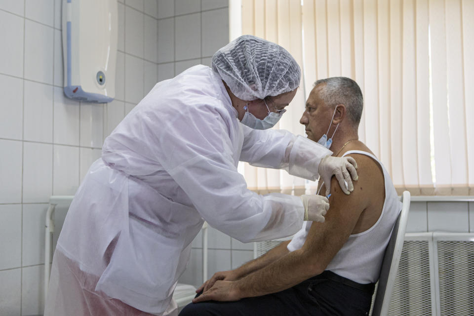 A Russian medical worker adminsters a shot of Russia's experimental Sputnik V coronavirus vaccine in Moscow, Russia, on Tuesday, Sept. 15, 2020. Russian health authorities have launched advanced trials of the vaccine among 40,000 volunteers, a randomized, placebo-controlled study. (AP Photo/Alexander Zemlianichenko Jr)