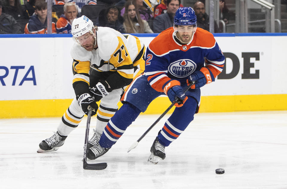 Pittsburgh Penguins' Jeff Carter (77) chases Edmonton Oilers' Evan Bouchard (2) during third-period NHL hockey game action in Edmonton, Alberta, Monday, Oct. 24, 2022. (Jason Franson/The Canadian Press via AP)