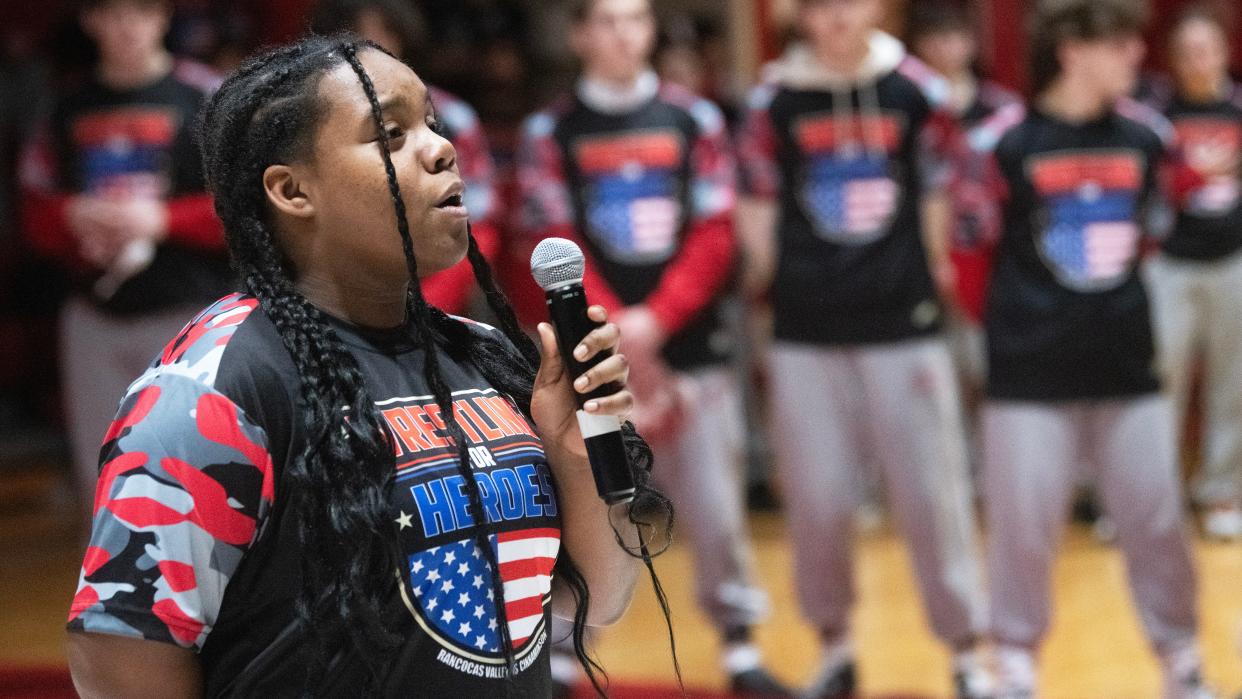Rancocas Valley wrestler Paris Ford sings the national anthem during a ceremony held prior to the 7th Annual Wrestling for Heroes Match held at Rancocas Valley High School on Wednesday, January 24, 2024.