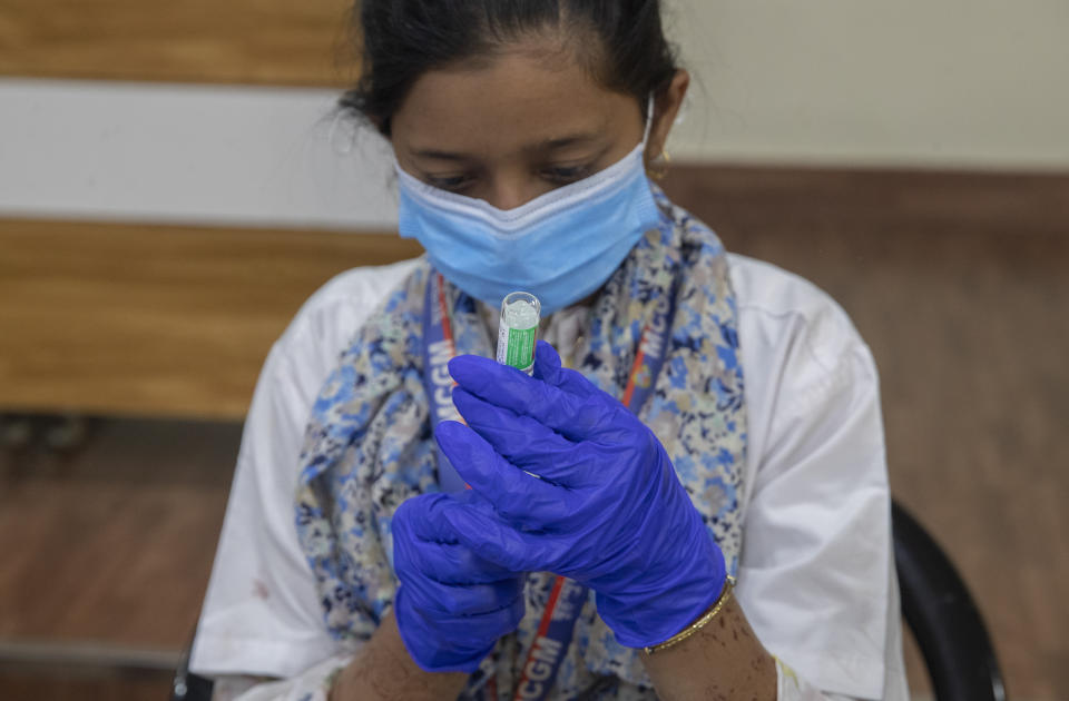 A health worker fills a syringe with a vial of the Covishield COVID-19 vaccine at a vaccination center in Mumbai, India, Monday, Nov. 29, 2021. (AP Photo/Rafiq Maqbool)