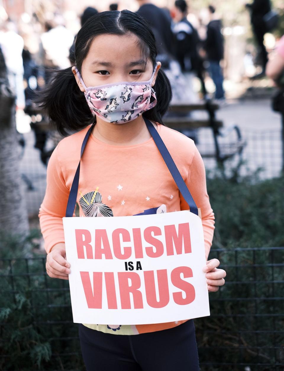 <p>A child in N.Y.C. holds a "racism is a virus" sign at the Rally Against Hate in N.Y.C. on March 21.</p>