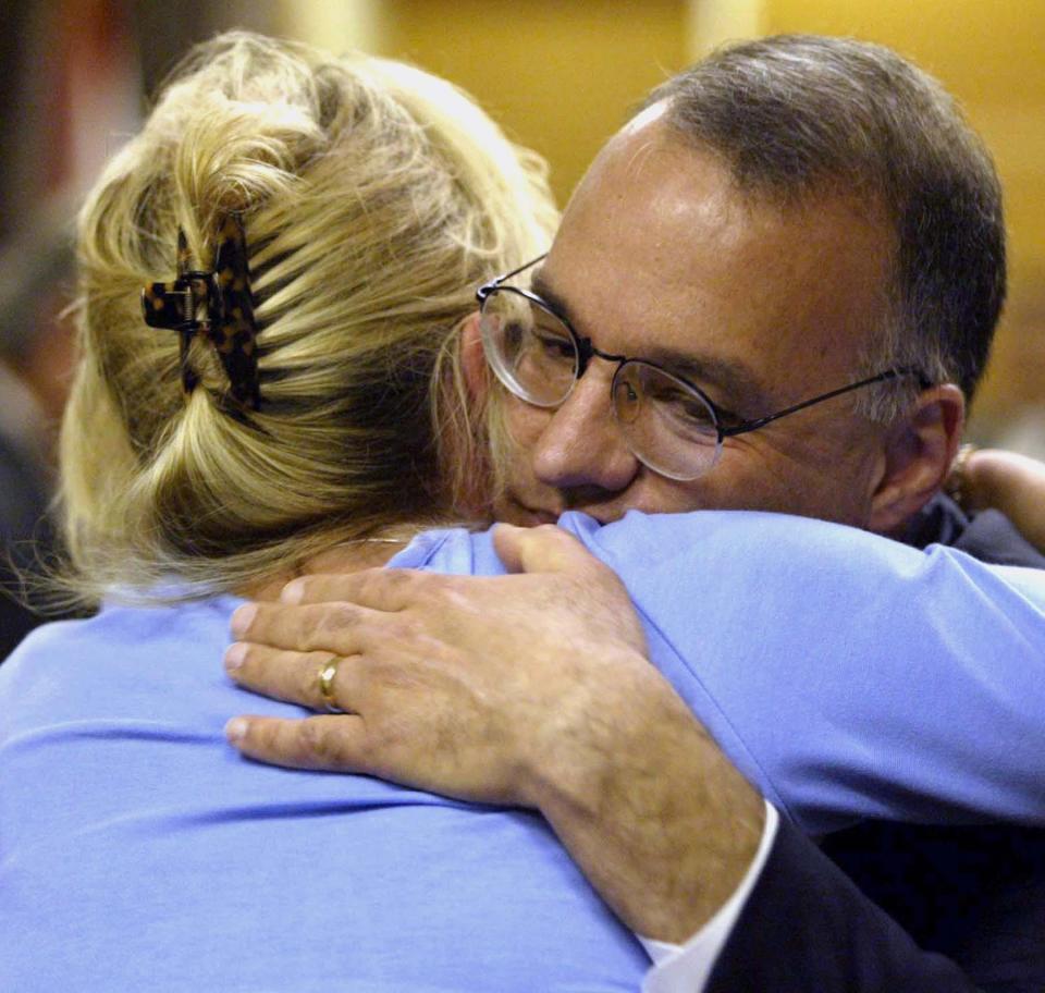 Assistant State Attorney Robert Belanger, right, hugs Leeana Fatovic, daughter of Frank Black, after Alan Mackerley was convicted of murdering Black, Saturday, March 15, 2003, at the Pinellas County Courthouse in Clearwater, Fla. Mackerley, a New Jersey bus company owner was found guilty of killing Black, a competitor, in 1996 and dumping his body in the Atlantic Ocean. (AP Photo/Charles Sonnenblick)