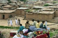 Afghan refugees and Pakistani tribal people leave with their belongings during an operation to demolish their poverty-stricken neighbourhood in Islamabad on July 31, 2015