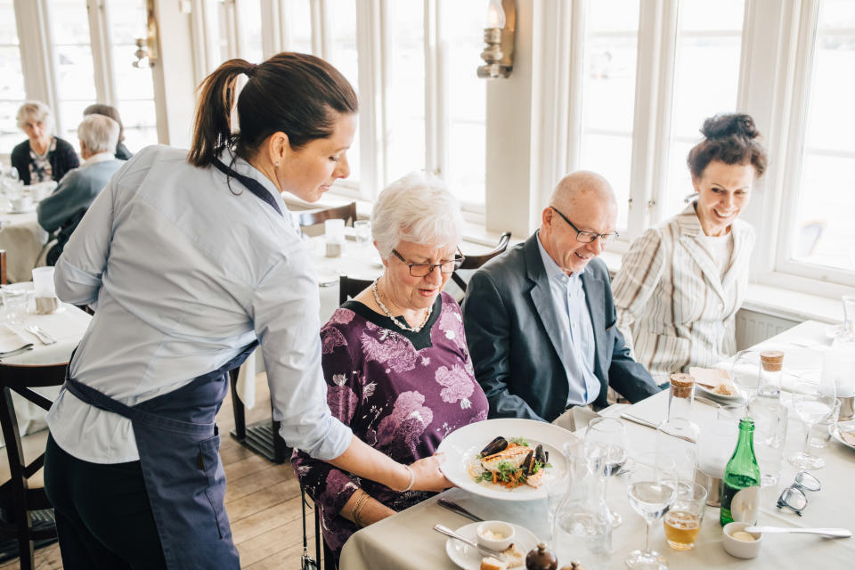 waiter placing food down at a table