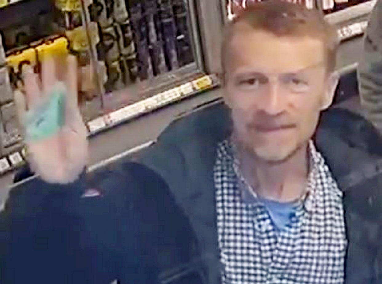 John Fletcher waves to a security camera in a shop when using a stolen credit card. (Kent Police / SWNS)