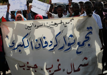 Sudanese protesters hold banners as they march through the defence ministry compound in Khartoum, Sudan, April 25, 2019. REUTERS/Umit Bektas