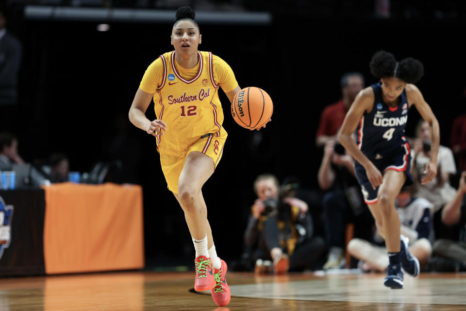 JuJu Watkins dribbles in game against UConn, focus on ball control and stance, action on basketball court
