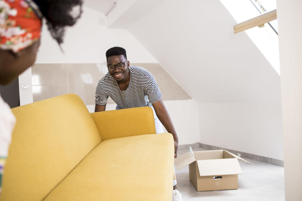 Man carrying in a yellow couch