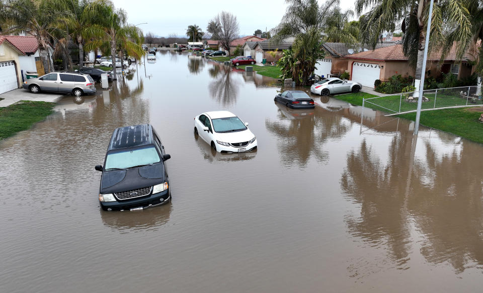 PLANADA, CALIFORNIA - JANUARY 11: In an aerial view, cars sit in floodwaters on January 11, 2023 in Planada, California. The Central Valley town of Planada was devastated by widespread flooding after a severe atmospheric river event moved through the area earlier in the week. The San Francisco Bay Area and much of California continues to be drenched by powerful atmospheric river events that have brought high winds and flooding rains. The storms have toppled trees, flooded roads and cut power to tens of thousands. Storms are lined up over the Pacific Ocean and are expected to bring more rain and wind through the end of the week. (Photo by Justin Sullivan/Getty Images)