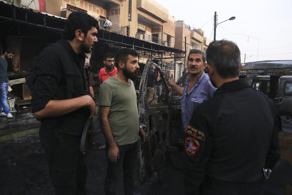 People gather after a car bomb exploded in the town of Qamishli, Syria, Friday, Oct. 11, 2019. Turkish forces faced intense resistance by U.S.-allied Syrian Kurdish fighters on the third day of Ankara's offensive, as casualties mounted, international criticism of the campaign intensified and an estimated 100,000 people fled the violence. (AP Photo/Baderkhan Ahmad)