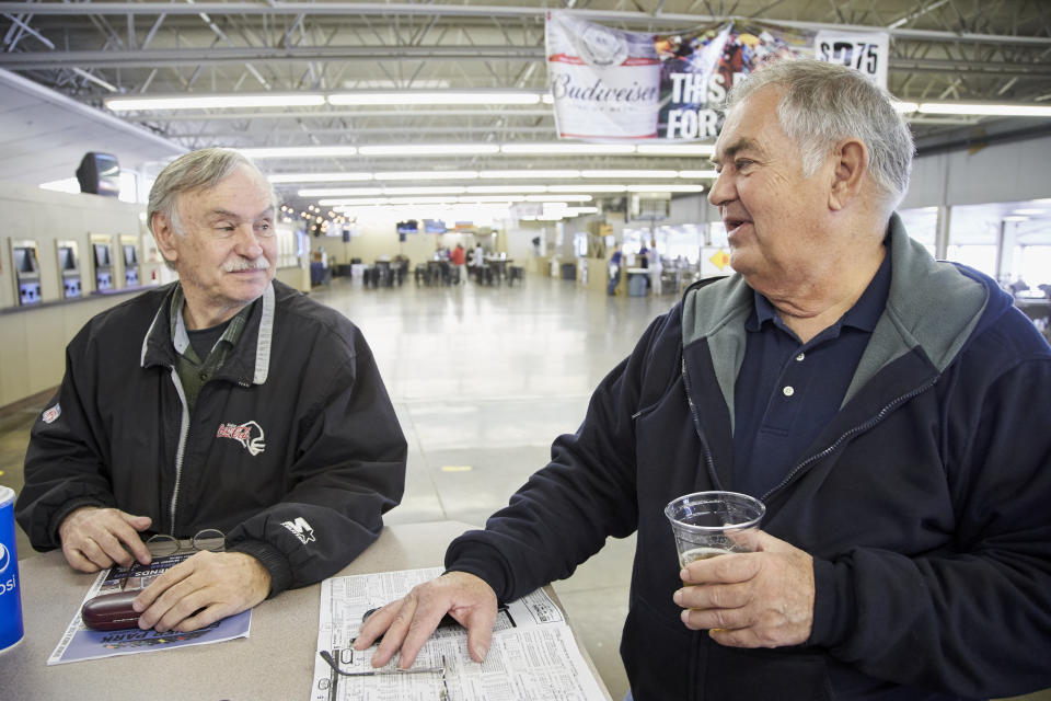 Ron Tenski and Jerry Moritz, right, who had arrived to Fonner Park in Grand Island, Neb., for the horse races, Saturday, March 14, 2020, prepares to leave after the races were called off due to dangerous track conditions following snowfall. Fonner was one of the few sporting venues in the country open to fans Saturday, and Moritz wasn't going to let concerns over the new coronavirus stop him from going to the track. "If we had a dozen people in the hospital here and two or three died, then I would probably back off," he said. "I feel like some people probably got it and don't even know it and are already over it." (AP Photo/Nati Harnik)