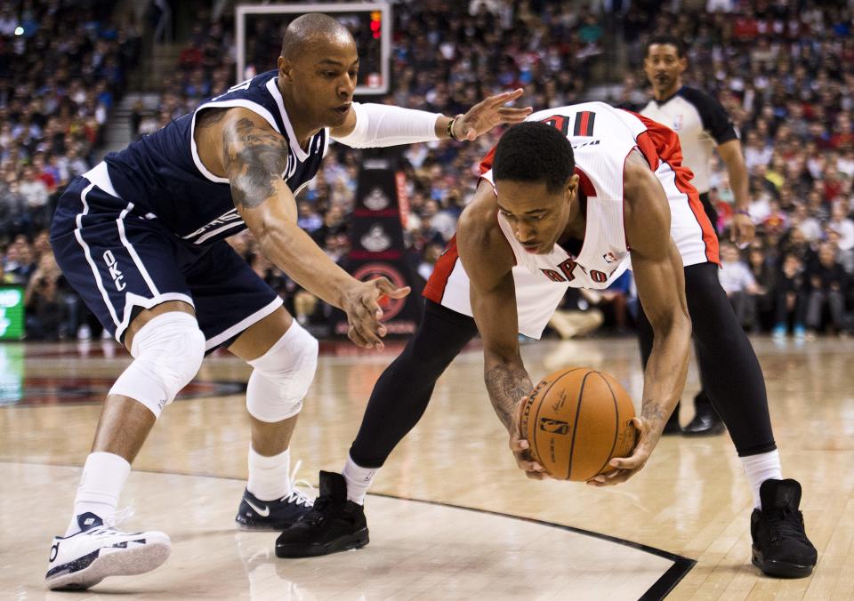 Toronto Raptors forward DeMar DeRozan, right, guards the ball against Oklahoma Thunder forward Caron Butler, left, during the first half of an NBA basketball game in Toronto on Friday, March 21, 2014. (AP Photo/The Canadian Press, Nathan Denette)