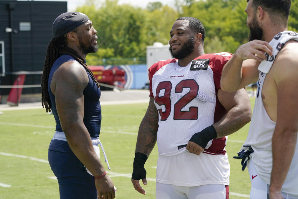 Tennessee Titans running back Derrick Henry, left, talks with Arizona Cardinals defensive tackle Antwaun Woods (92) following a joint practice during NFL football training camp Wednesday, Aug. 24, 2022, in Nashville, Tenn. (AP Photo/Mark Humphrey)