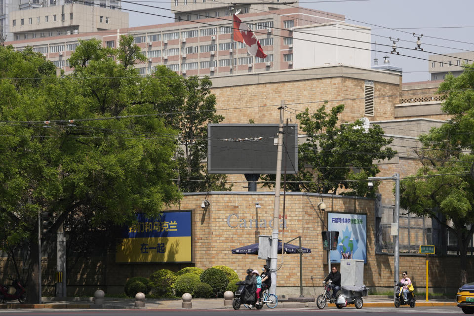 Residents pass by the Canadian embassy in Beijing, Tuesday, May 9, 2023. China announced the expulsion of a Canadian diplomat on Tuesday in retaliation for Ottawa ordering a Chinese consular official to leave the country over alleged threats he made against a Canadian lawmaker and his family. (AP Photo/Ng Han Guan)