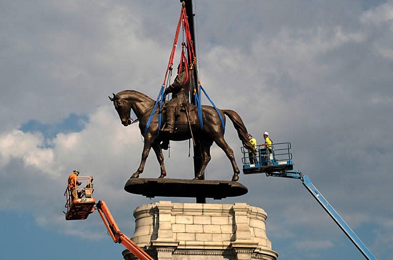 RICHMOND, VIRGINIA - SEPTEMBER 08: The statue of Confederate General Robert E. Lee is removed from its pedestal on Monument Avenue on September 8, 2021 in Richmond, Virginia. The Commonwealth of Virginia is removing the largest Confederate statue remaining in the U.S. following authorization by all three branches of state government, including a unanimous decision by the Supreme Court of Virginia.