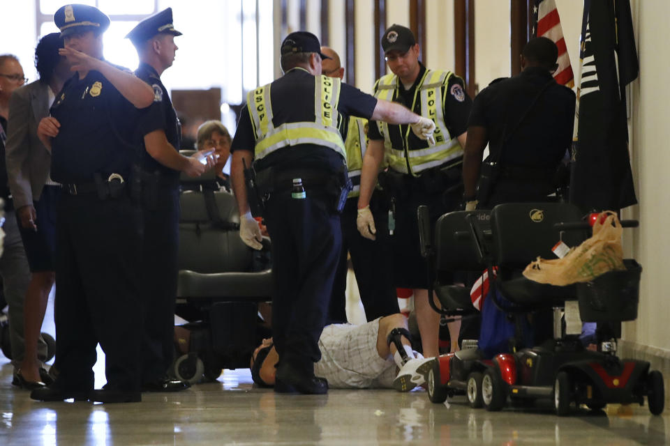 <p>Capitol Police prepare to remove a man from a sit-in of Senate Majority Leader Mitch McConnell’s office, as he and others protest proposed caps to Medicaid Thursday, June 22, 2017, on Capitol Hill in Washington. (Photo: Jacquelyn Martin/AP) </p>