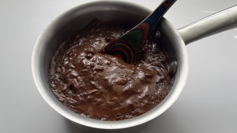 chocolate rice pudding in a pot with a spoon in it