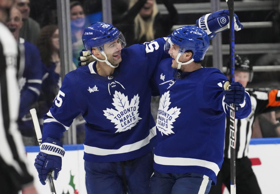 Toronto Maple Leafs' Alexander Kerfoot, right, celebrates his goal against the Anaheim Ducks with teammate Mark Giordano during the third period of an NHL hockey game in Toronto on Tuesday, Dec. 13, 2022. (Frank Gunn/The Canadian Press via AP)