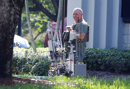 Broward County Sheriff's Office bomb squad officer operates a robot outside a building containing the office of U.S. Rep. Debbie Wasserman Schultz as the Broward County Sheriff's Office bomb squad performs a search in Sunrise, Florida, U.S. October 24, 2018. REUTERS/Joe Skipper