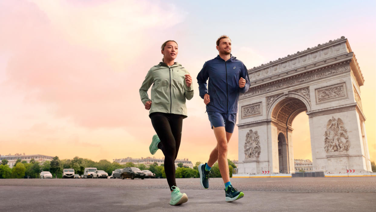  Male and female runners wearing Asics Gel-Nimbus 26 run past Arc de Triomphe. 