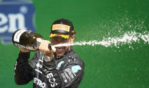 Mercedes driver Lewis Hamilton, of Britain, sprays champagne at the podium after winning the Brazilian Formula One Grand Prix at the Interlagos race track in Sao Paulo, Brazil, Sunday, Nov. 14, 2021. (AP Photo/Andre Penner)