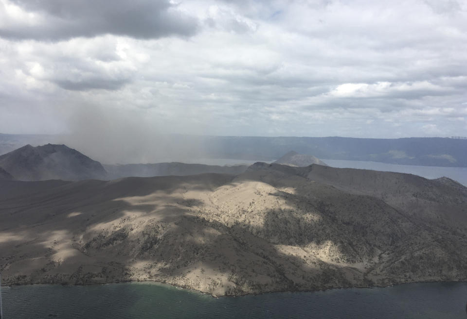In this Jan. 21, 2020, handout photo provided by the Office of Civil Defense, Taal volcano emits small amounts of ash in Batangas province, southern Philippines. The government will no longer allow people to live on the crater-studded island that's home to the volcano. (Office of Civil Defense via AP)