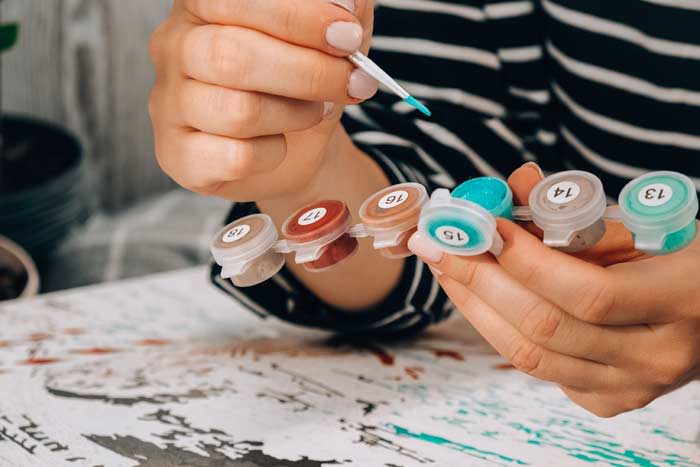 mujer pintando con acuarelas numeradas