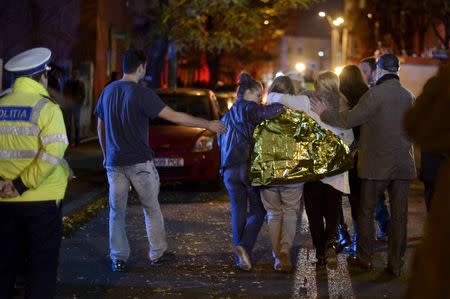 People walk outside a nightclub following an explosion in Bucharest, Romania October 31, 2015. REUTERS/Inquam Photos