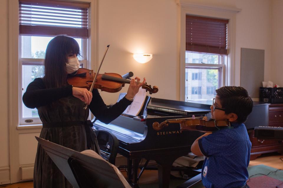 Cesar Gabriel Marin Rivera, 7, learns the proper posture needed to play the violin from WCM's Talia Pavia, who chairs the conservatory's string department. He and his two siblings received free violins thanks to the conservatory's biennial instrument drive taking place Saturday, Oct. 7, at four Milwaukee-area locations.