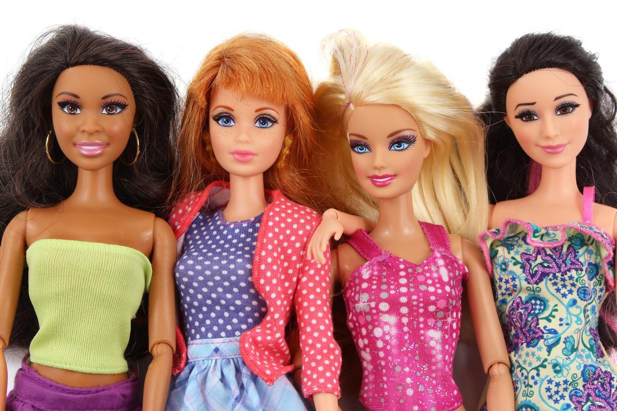 four Barbie fashion dolls in different ethnic backgrounds