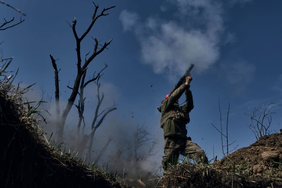 A Ukrainian soldier fires a grenade launcher on the frontline in Bakhmut (AP)
